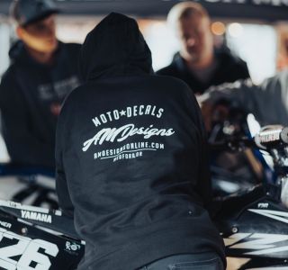 Guy leaning against bole with AMDesigns Hoodie